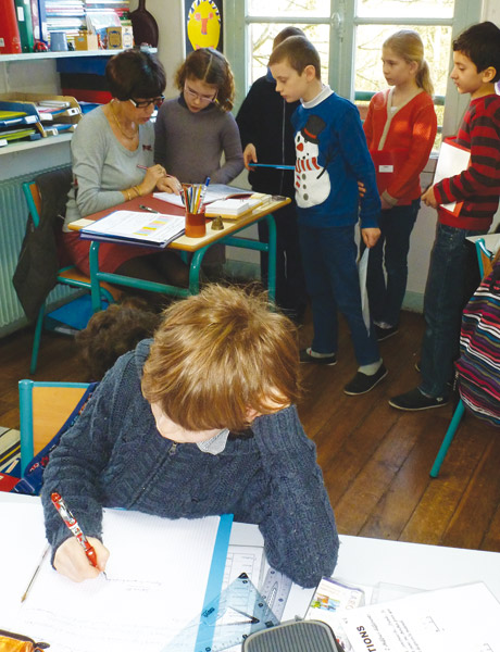 classe-ecole-active-pierre-faure Les élèves qui ont achevé leur tâche en autonomie viennent faire vérifier leur travail par l’enseignante.