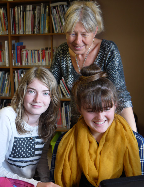 Trois collégiennes relisant des articles. Derrière : la documentaliste du collège, Joëlle Roux.